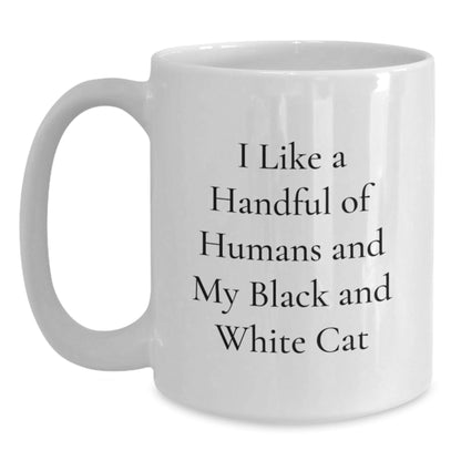 Funny Black and White Cat Gifts from Friends and Family, I Like A Handful Of Humans And My Black And White Cat White Coffee Mug for Graduation, Unique and Humorous Ceramic Mug for Men and Women - Victory Thru Vision