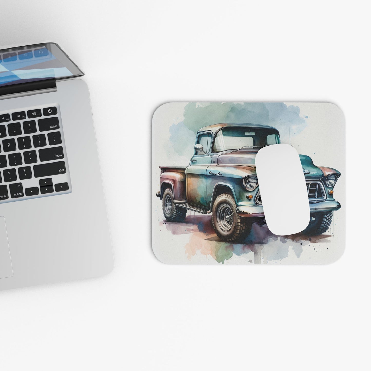 Mouse pad with vintage 1955 Chevy truck illustration, rustic office decor on white desk.
